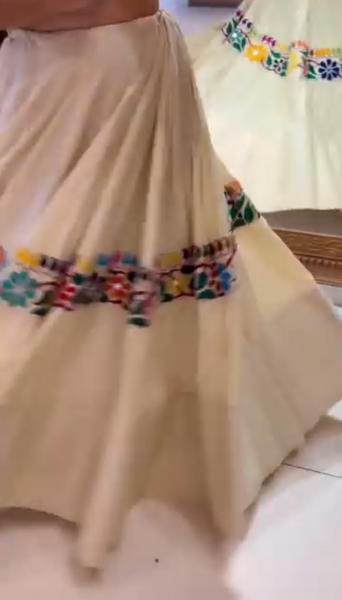 Beige skirt with colorful floral patterns on a white background